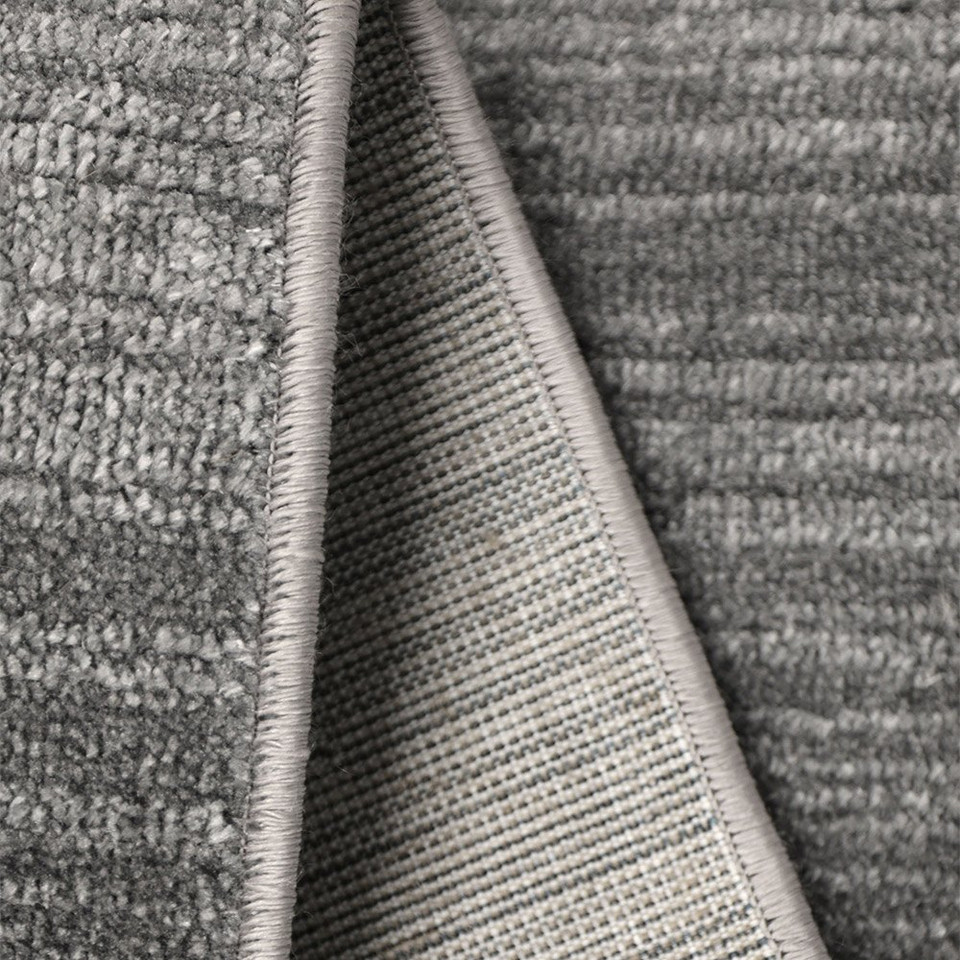 Arlo Textured Grey Rug folded, exposing the backing.