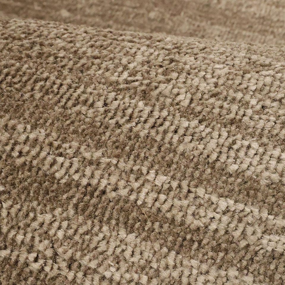 Arlo Textured Natural Rug in a living space with a seating arrangement.
