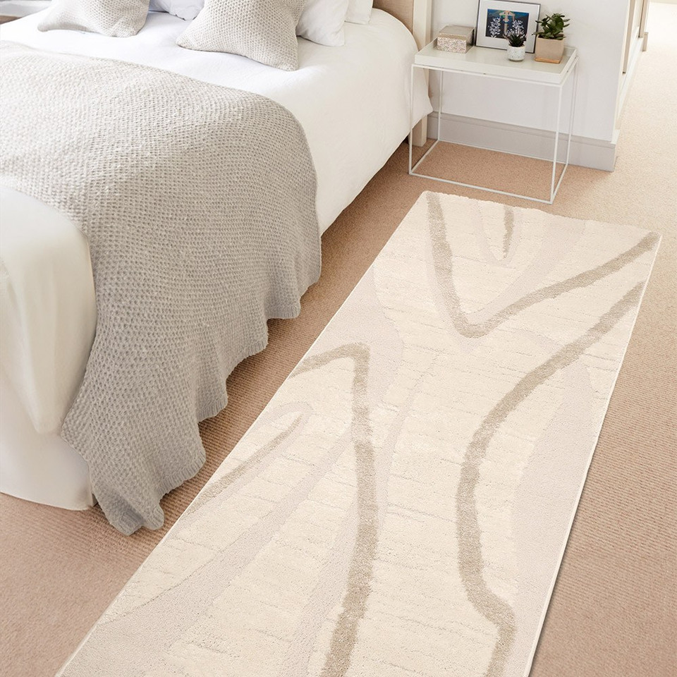 Ava Wave Cream Rug in a bedroom beside a bed