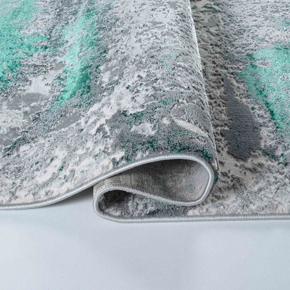 aqua grey abstract rug folded on white floor