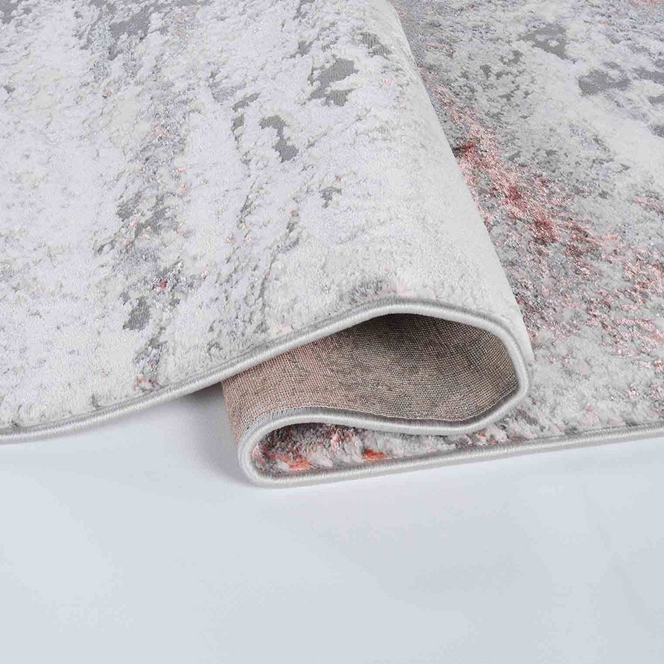 pink grey abstract rug runner folded on a while floor