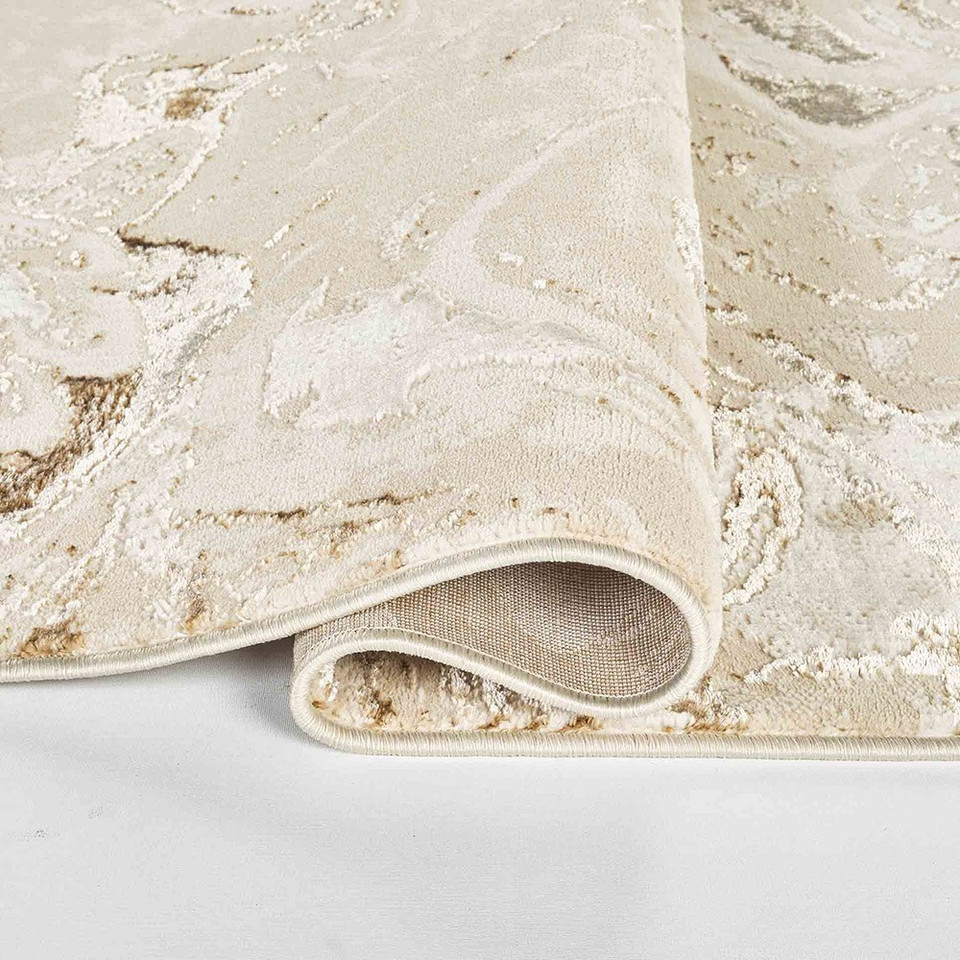 beige abstract rug folded on a white floor