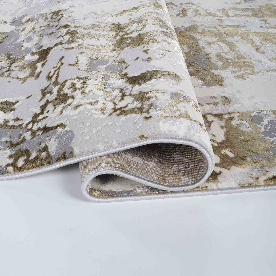 gold grey abstract rug runner folded on a white floor