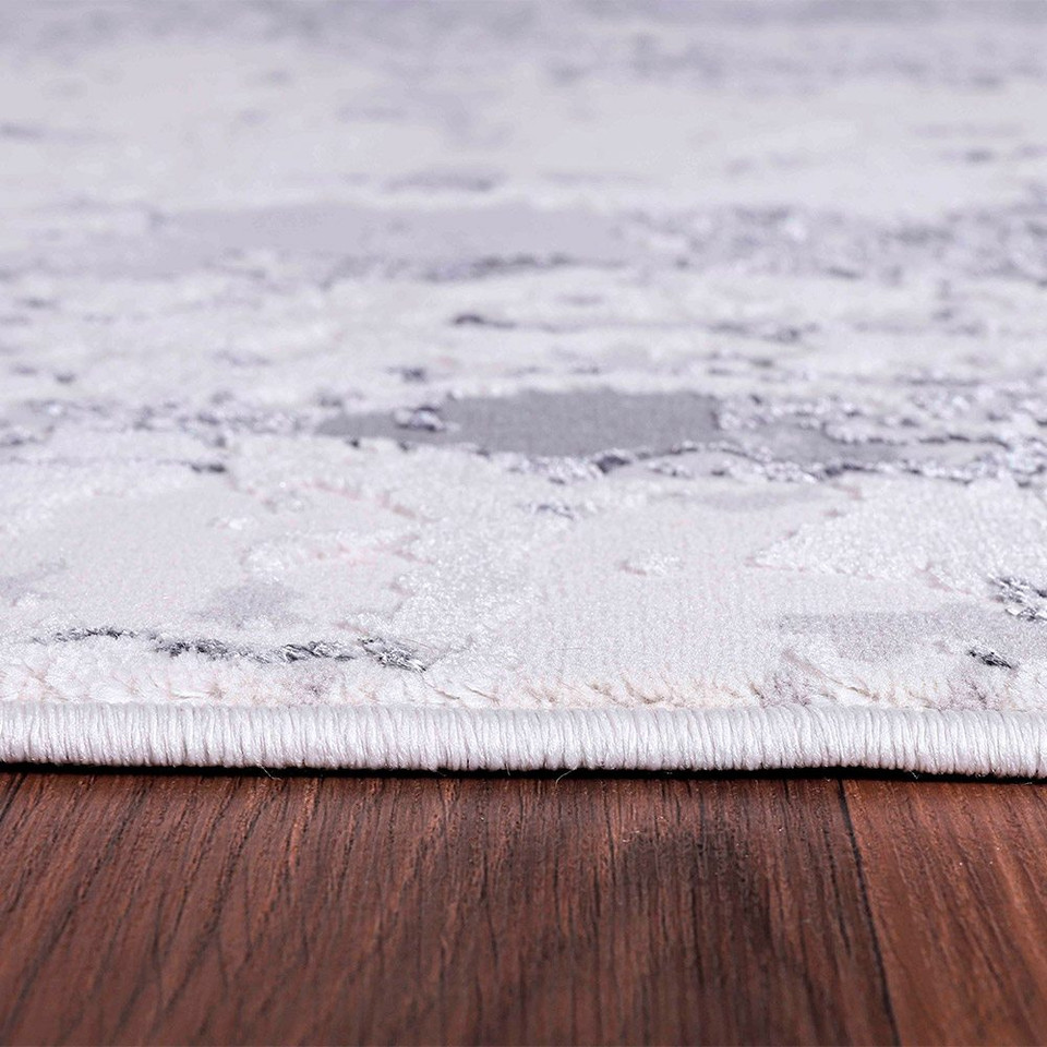 grey abstract rug closeup edge on wooden floor