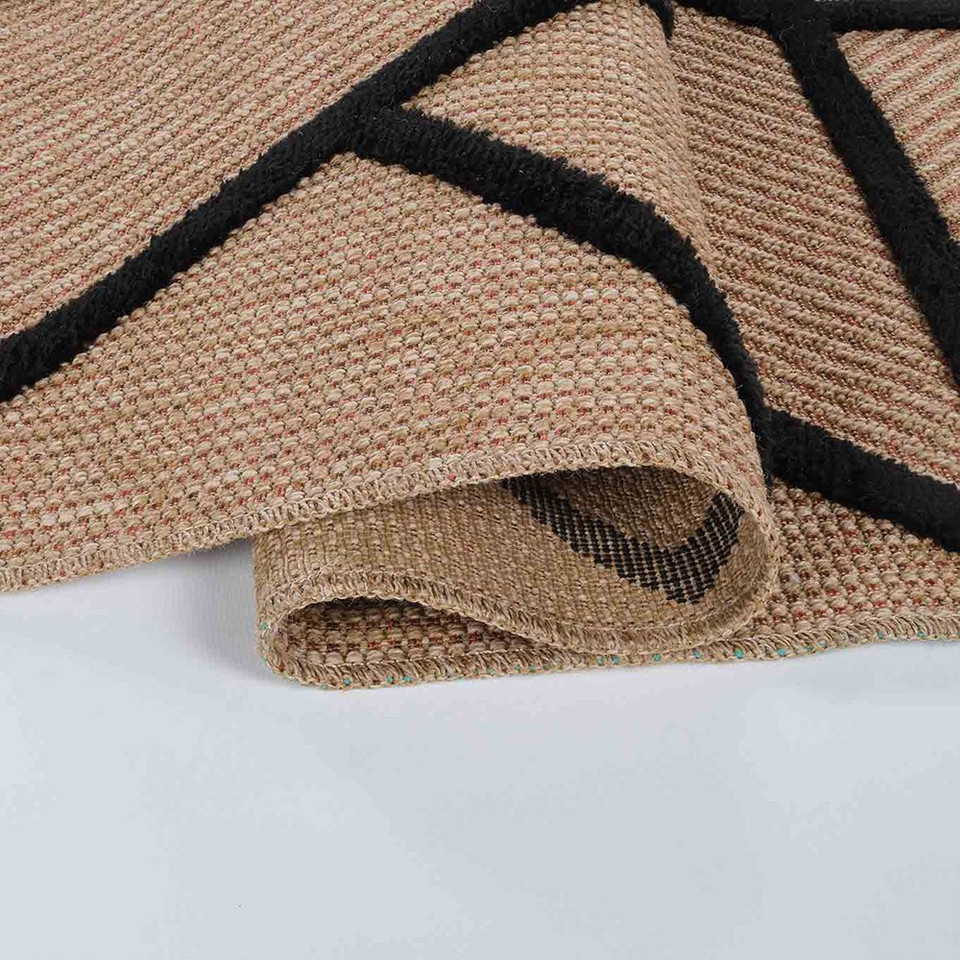 black natural geometric rug folded on white floor