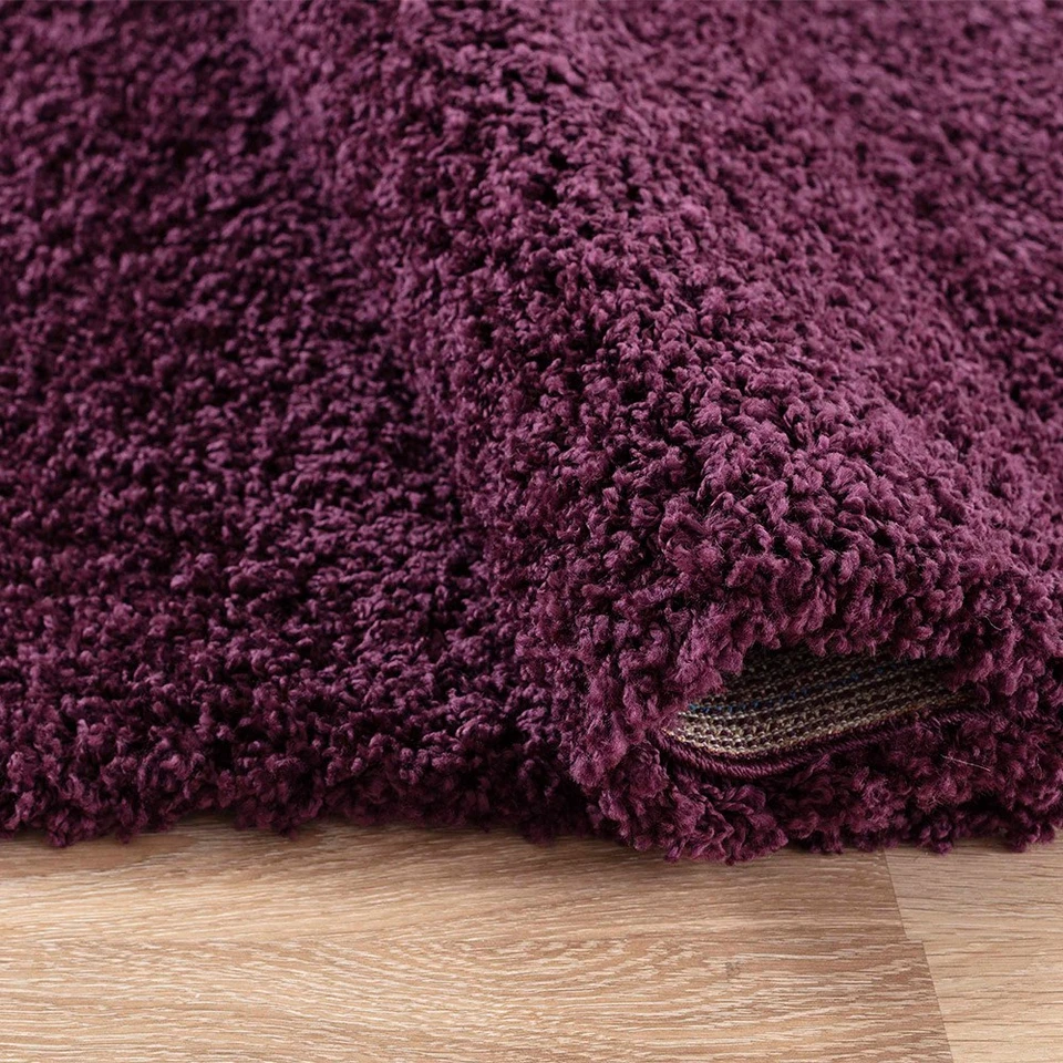 plain shaggy violet rug folded on white floor