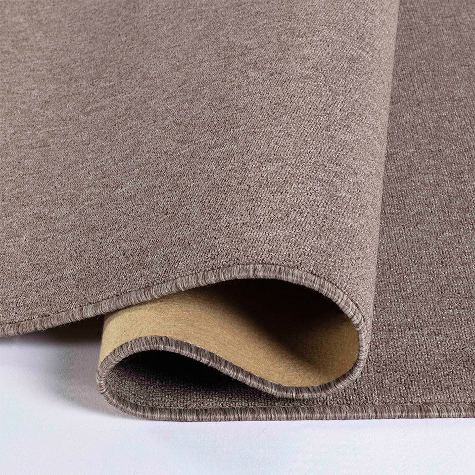 plain low pile dark beige rug folded on white floor