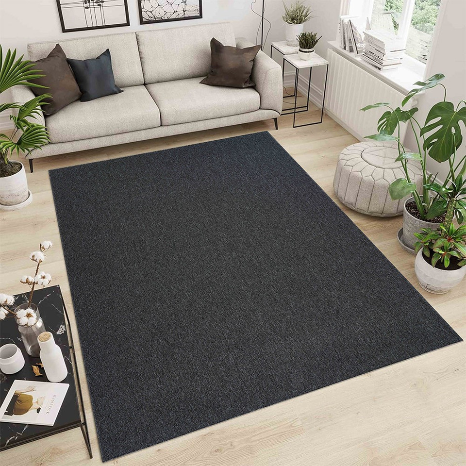 plain low pile dark grey rug in a living room with a wooden floor