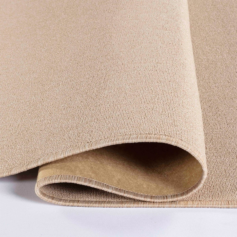 plain low pile light beige rug folded on white floor
