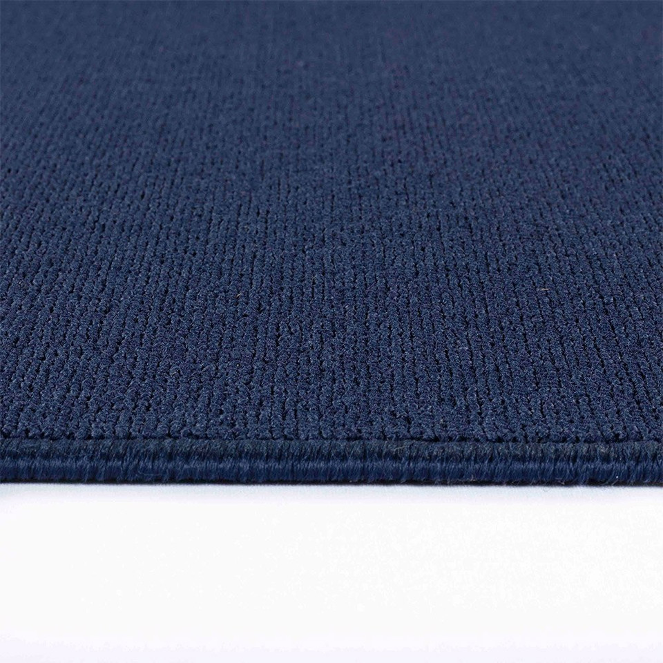 plain low pile navy rug runner closeup edge on white floor
