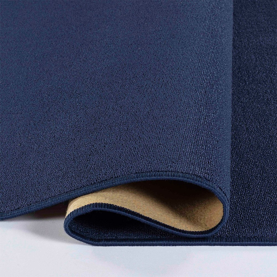 plain low pile navy rug runner folded on white floor