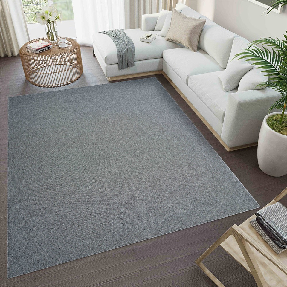 plain low pile silver rug in a living room with a dark floor