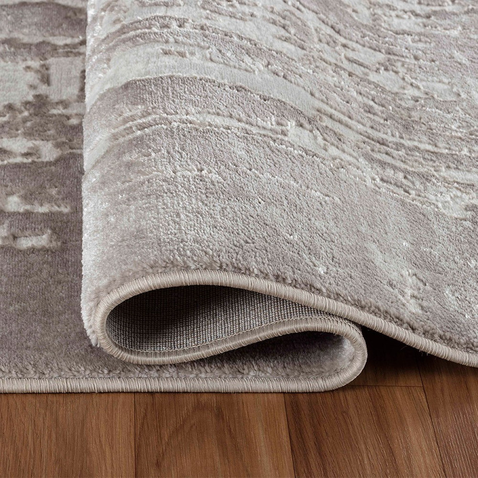 modern abstract abrasion stone rug runner folded on a wooden floor