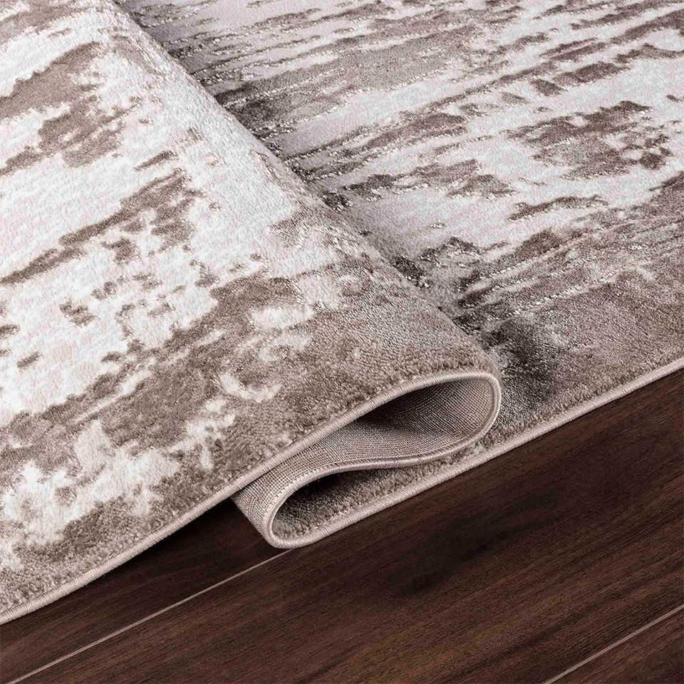modern abstract abrasion stone rug folded on a wooden floor