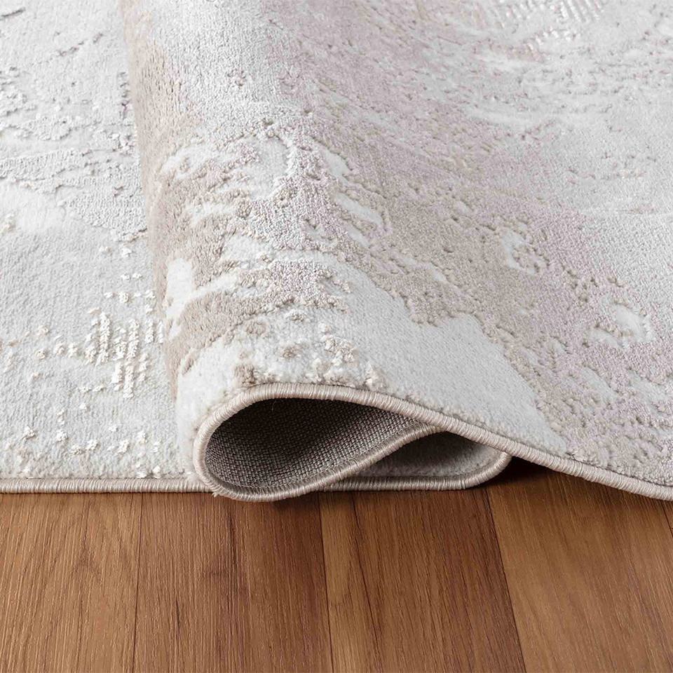 modern abstract sprayed stone rug runner folded on a wooden floor
