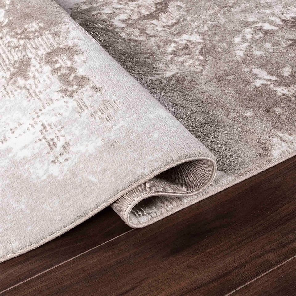 modern abstract sprayed stone rug runner folded on a wooden floor