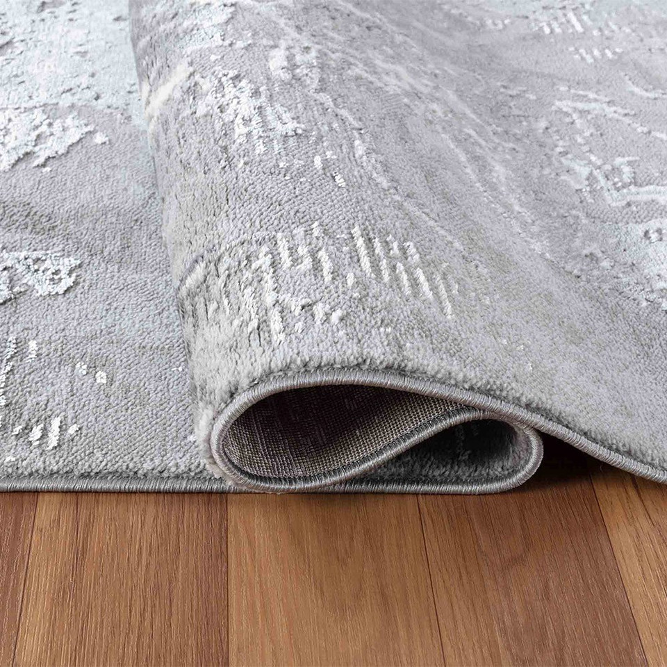 modern abstract water flow grey rug folded on wooden floor