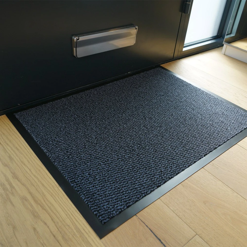 blue non-slip dirt trapper mat in front of a door indoors