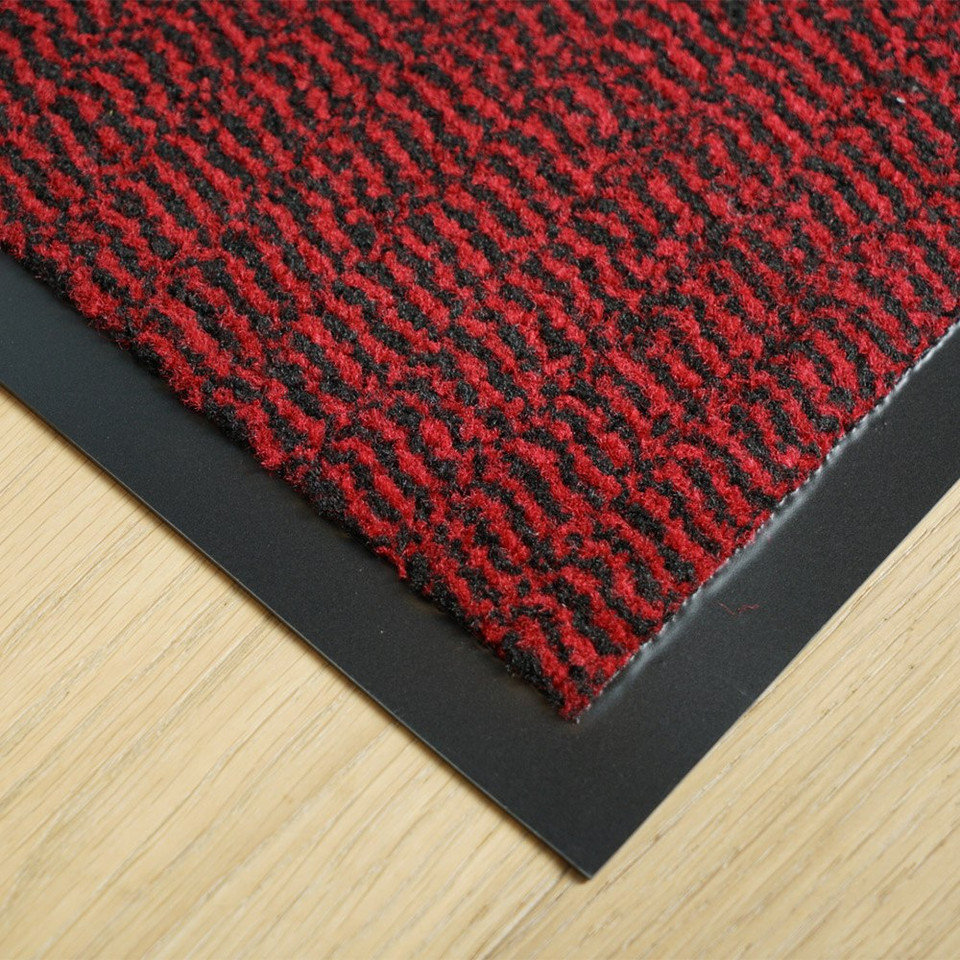 red non-slip dirt trapper mat closeup corner on wood floor