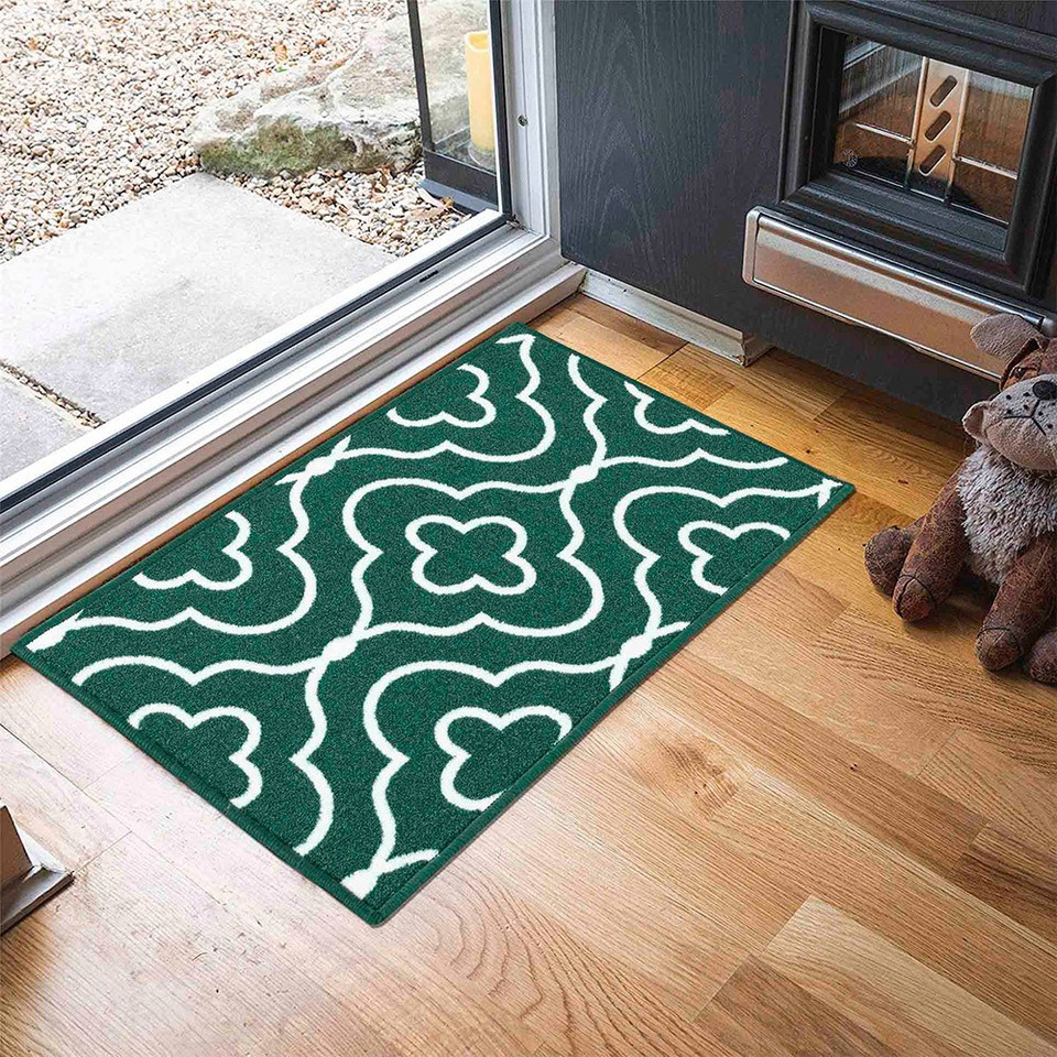 quatrefoil emerald doormat in a door way on a wood floor