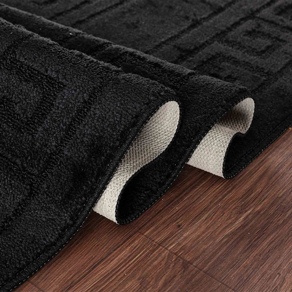 greek key black doormat folded on wooden floor