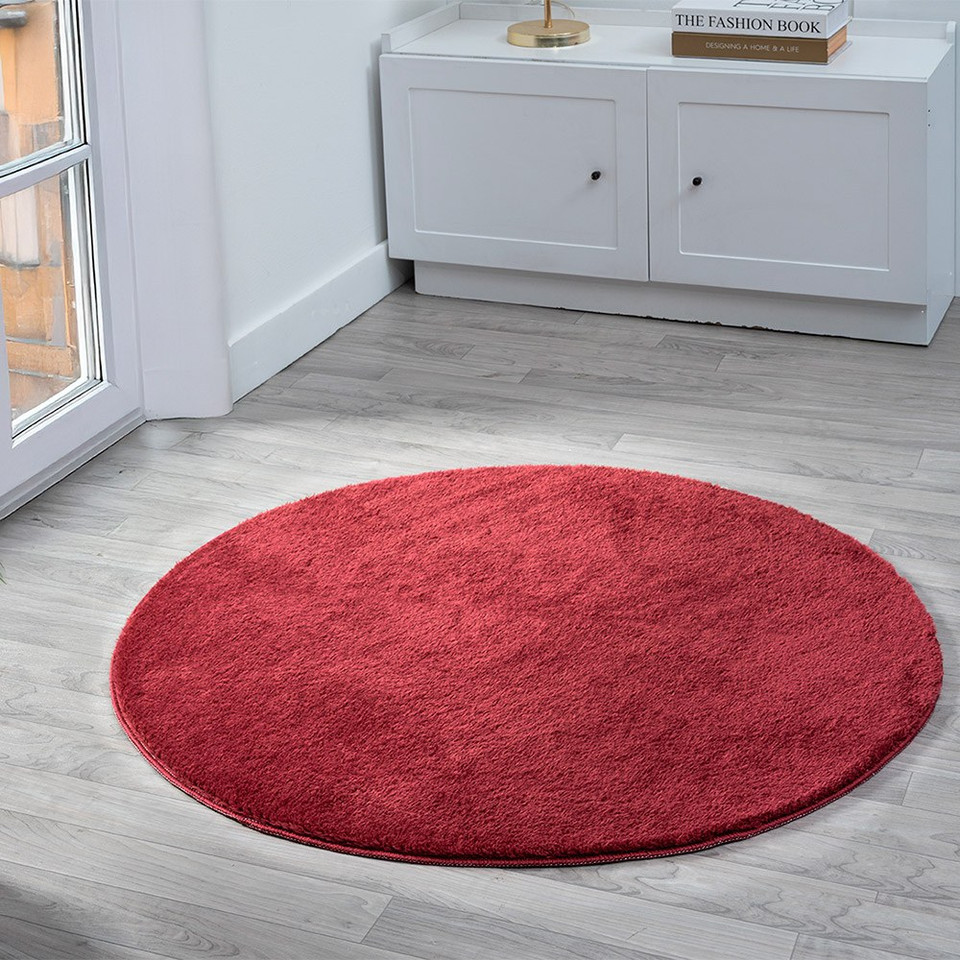 plain red rug circle in a living space with a window