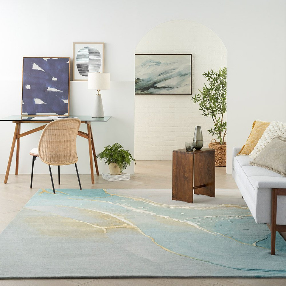 grey seafoam abstract rug in a room with a sofa and workstation