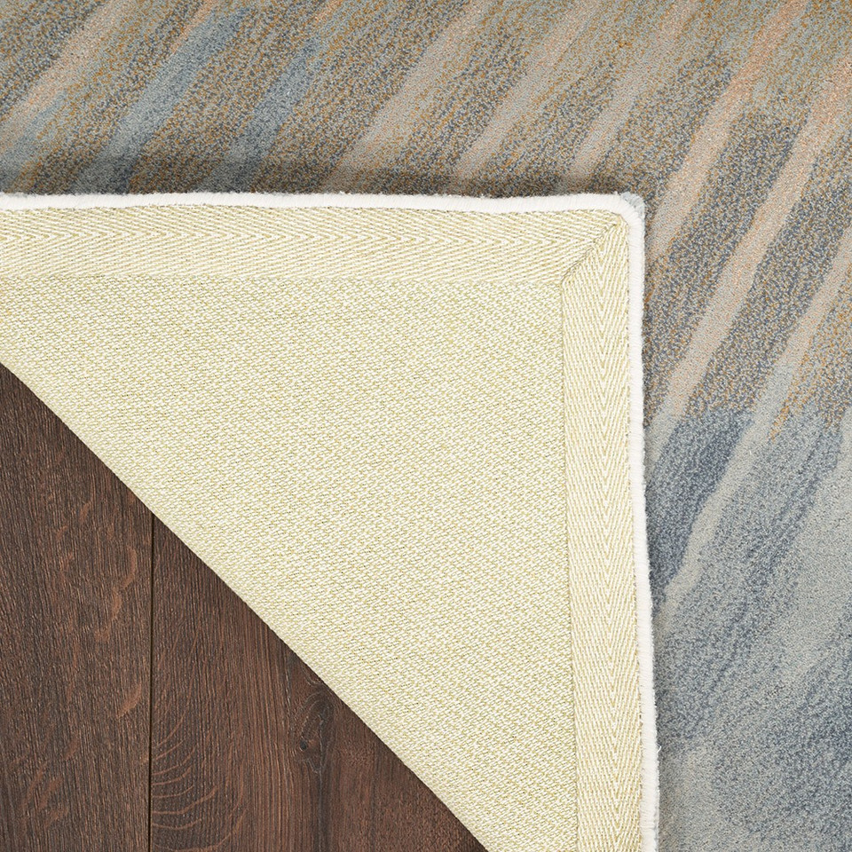 sand abstract rug closeup corner folded on dark wood floor