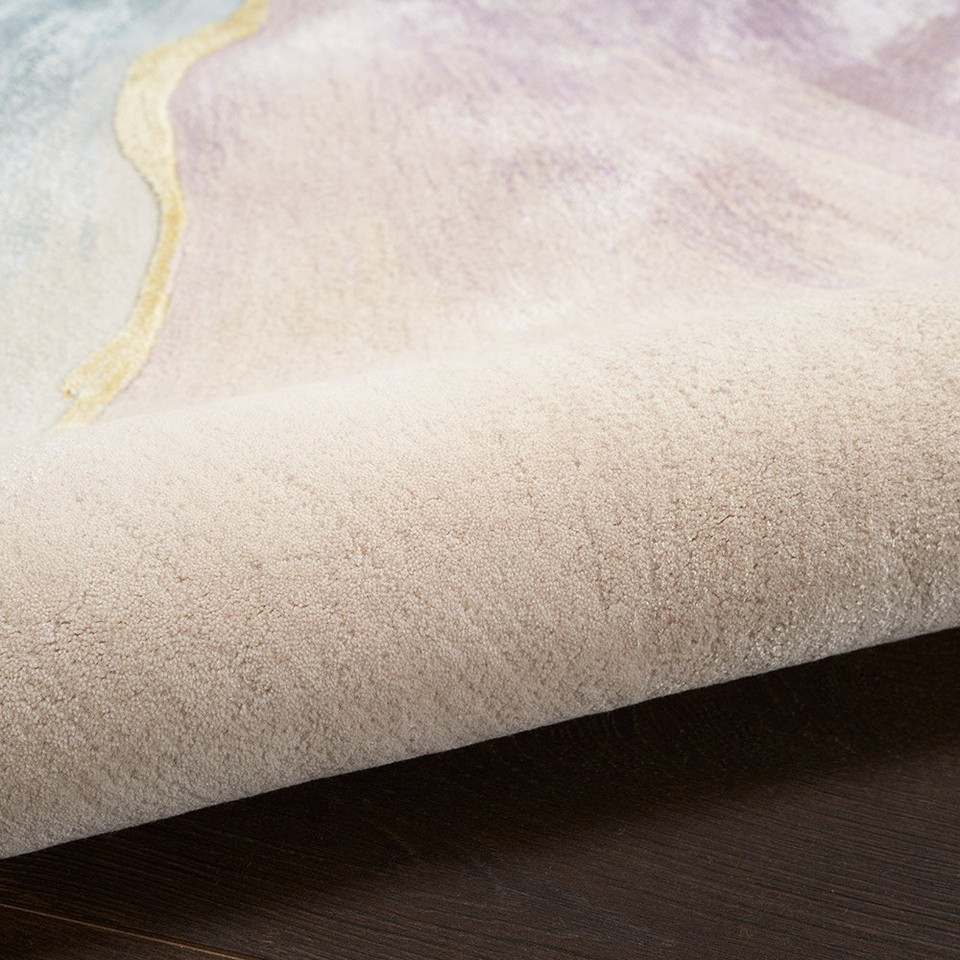 ivory floral rug partially rolled on a dark wood floor