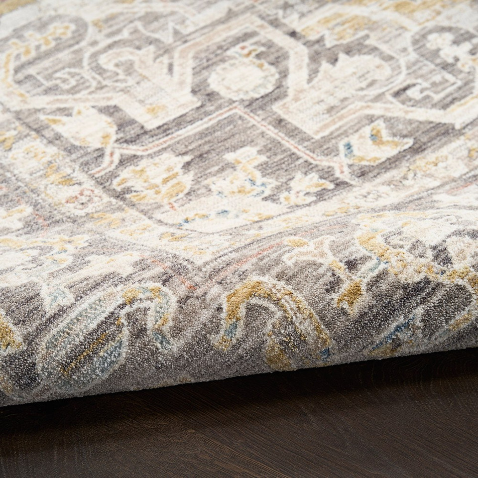 grey traditional rug closeup rolled on dark wood floor