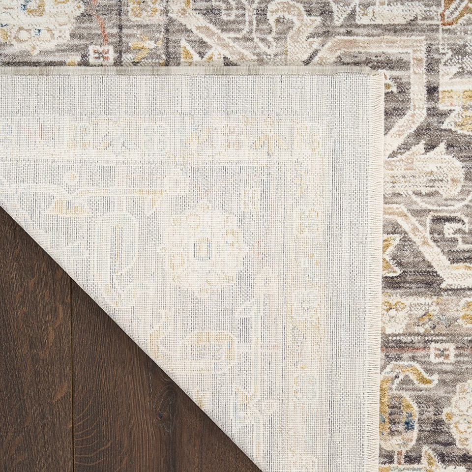 grey traditional rug closeup corner folded on dark wood floor