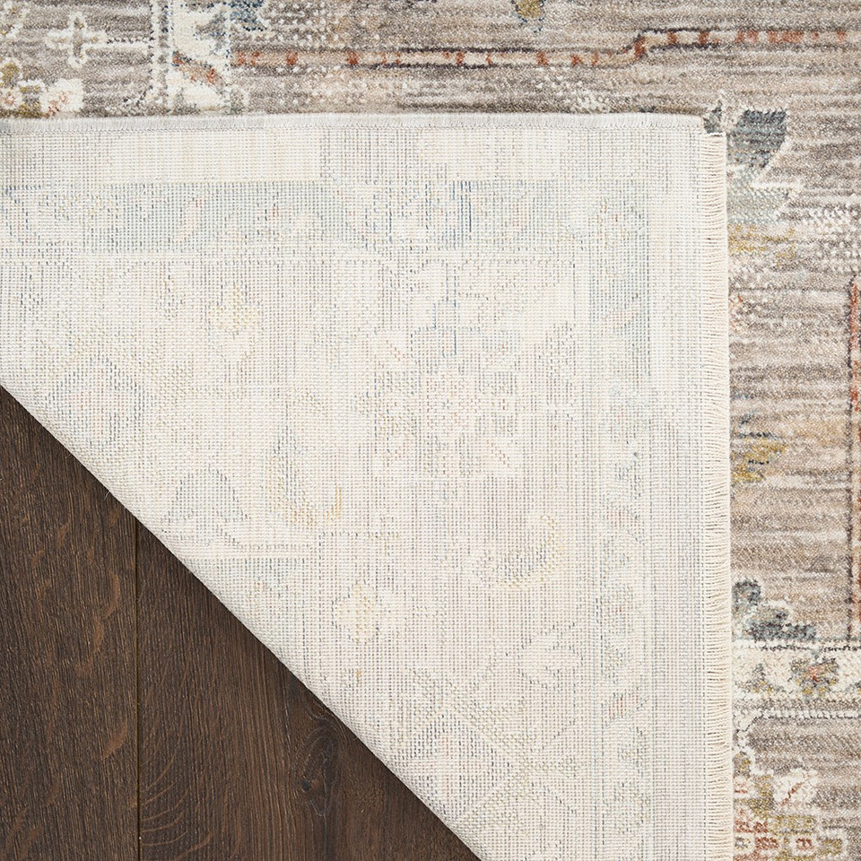 ivory traditional rug closeup corner folded on dark wood floor