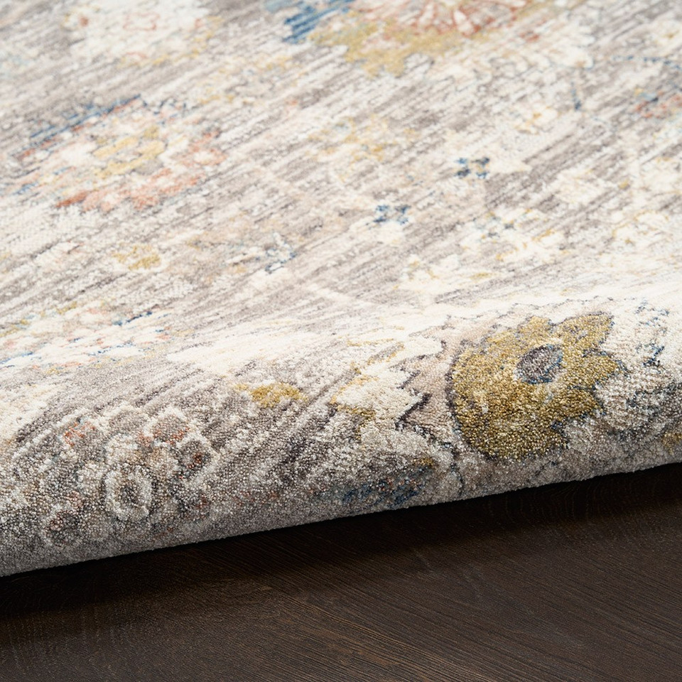 grey traditional rug closeup rolled on dark wood floor