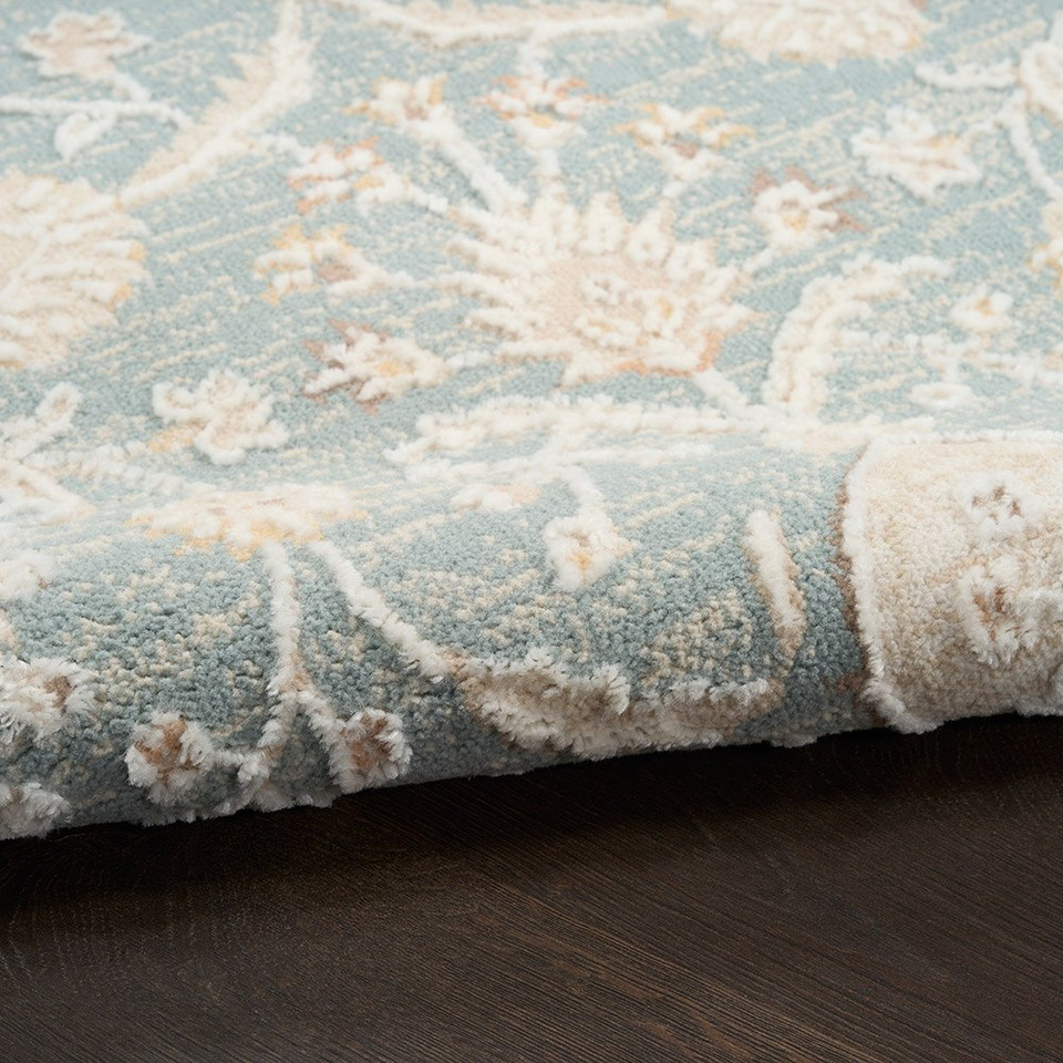 blue traditional rug closeup rolled with dark wood floor