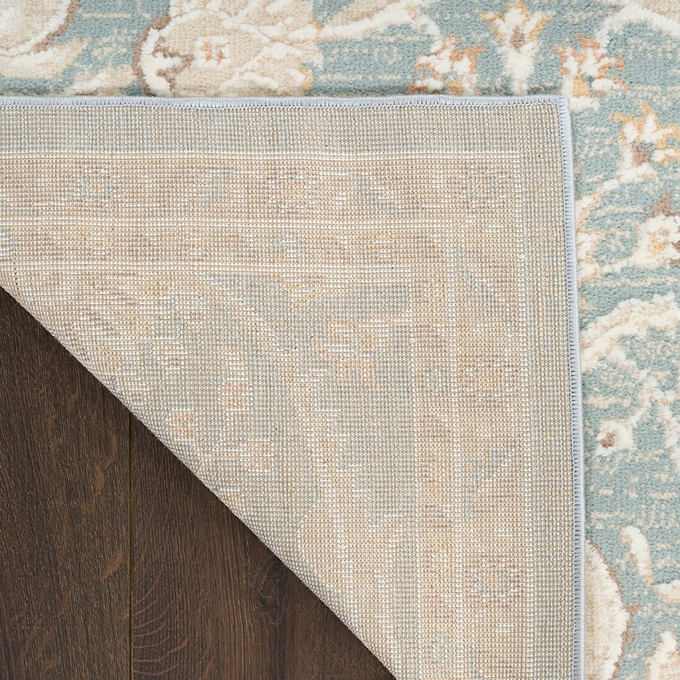 blue traditional rug closeup corner fold with dark wood floor