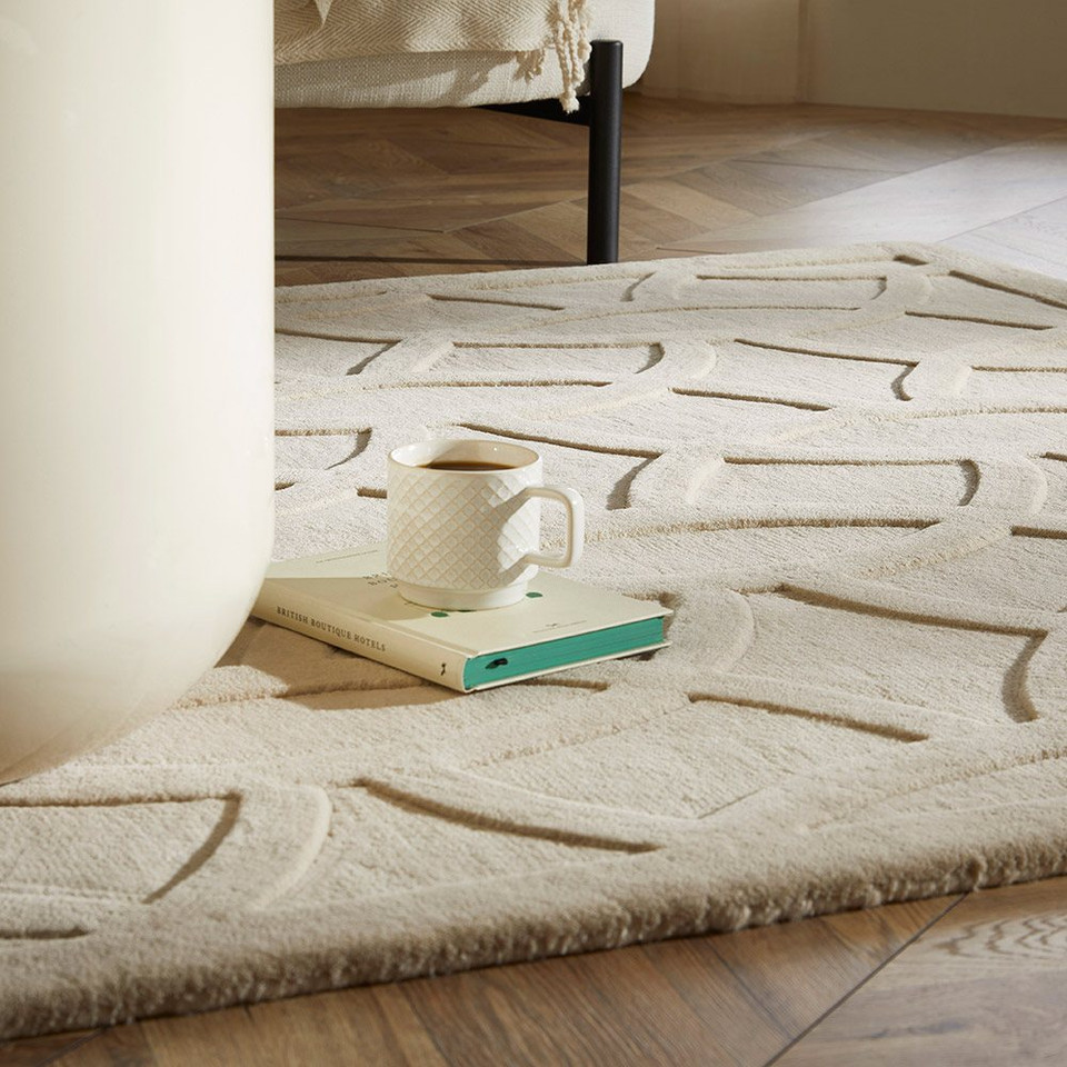 beige wool rug closeup with book and tea cup