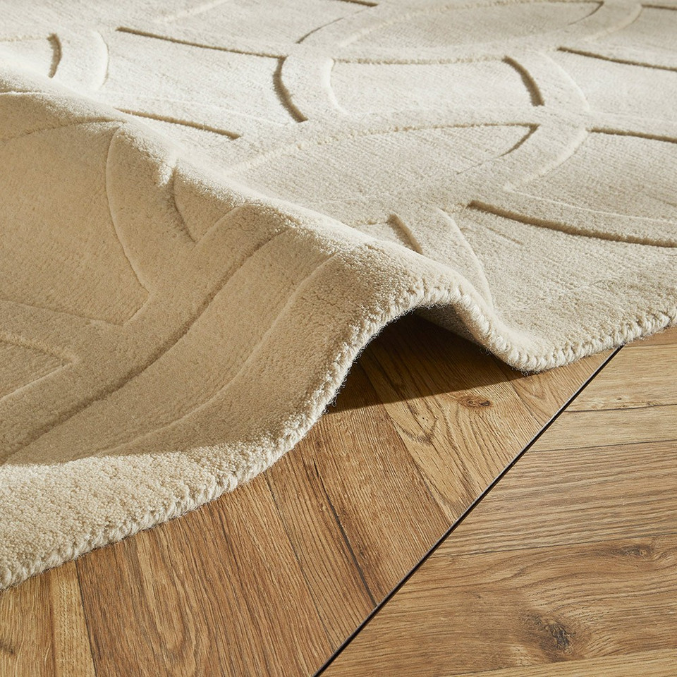 ivory wool rug closeup fold on wood floor