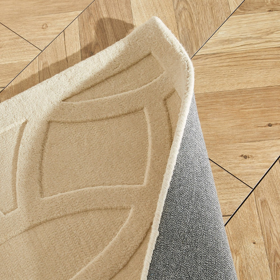 ivory wool rug closeup fold on wood floor