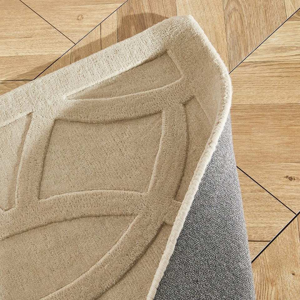 taupe wool rug closeup fold on wood floor