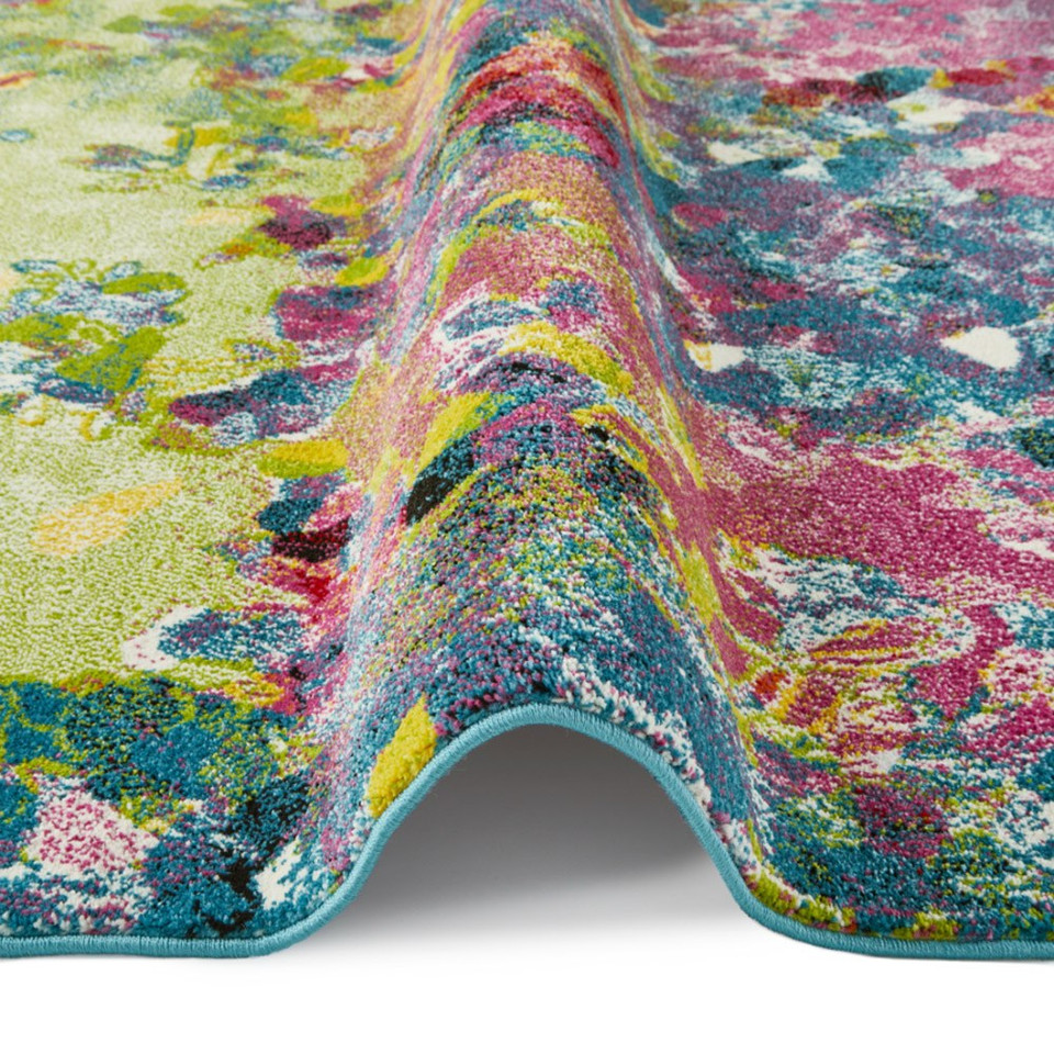 multicolour abstract rug partially folded on a white floor