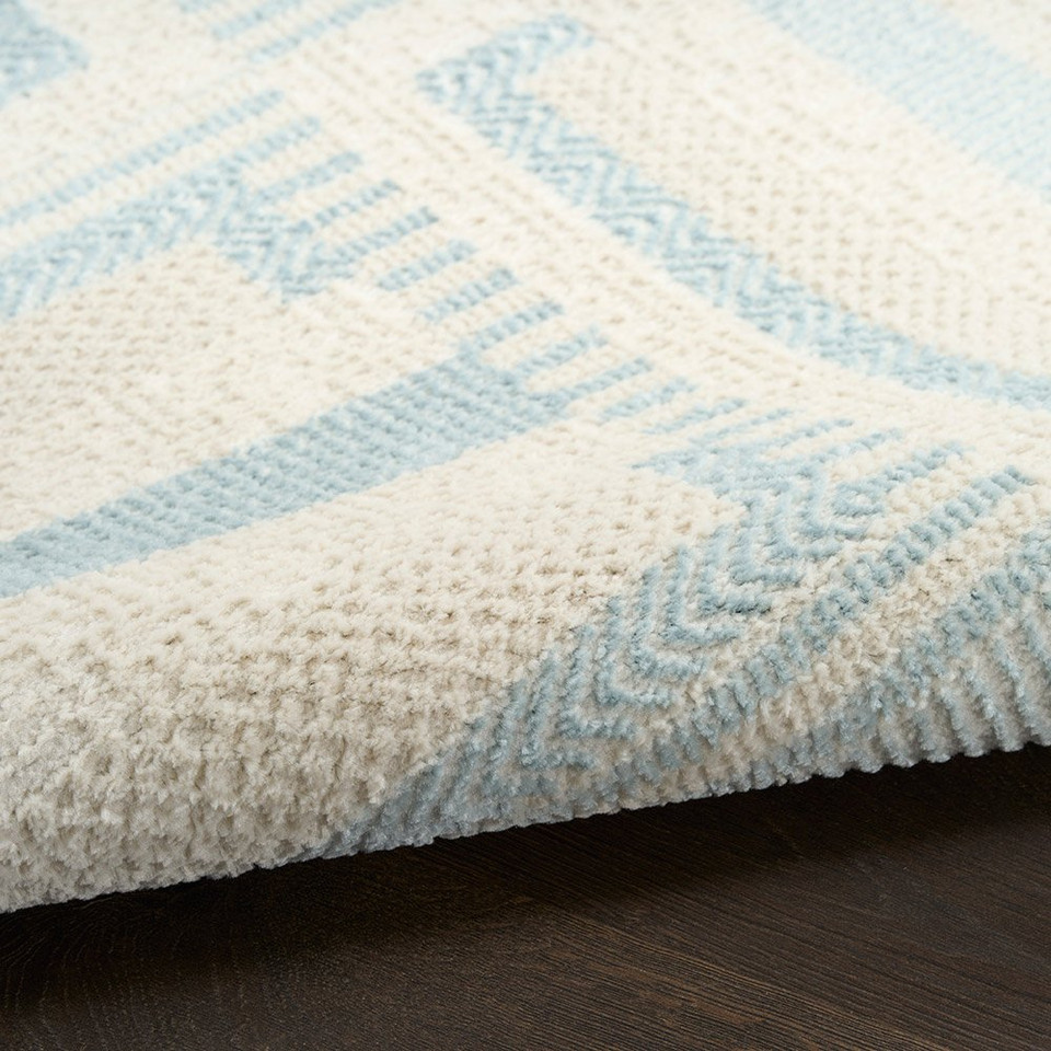 ivory blue geometric rug partially rolled