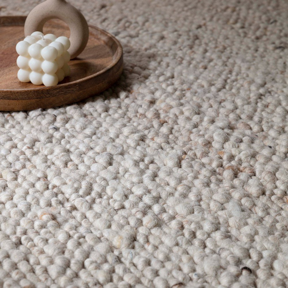 ivory wool rug closeup detail with wood plate