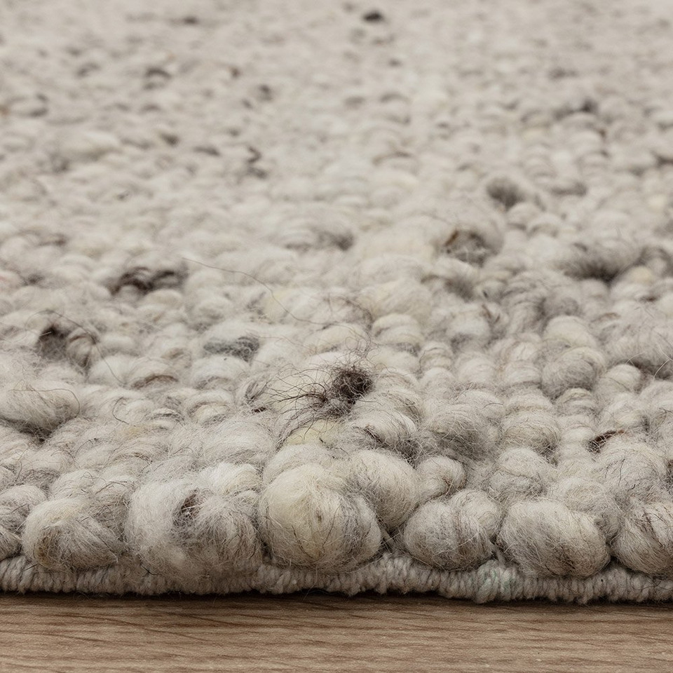 silver wool rug closeup edge on wood floor