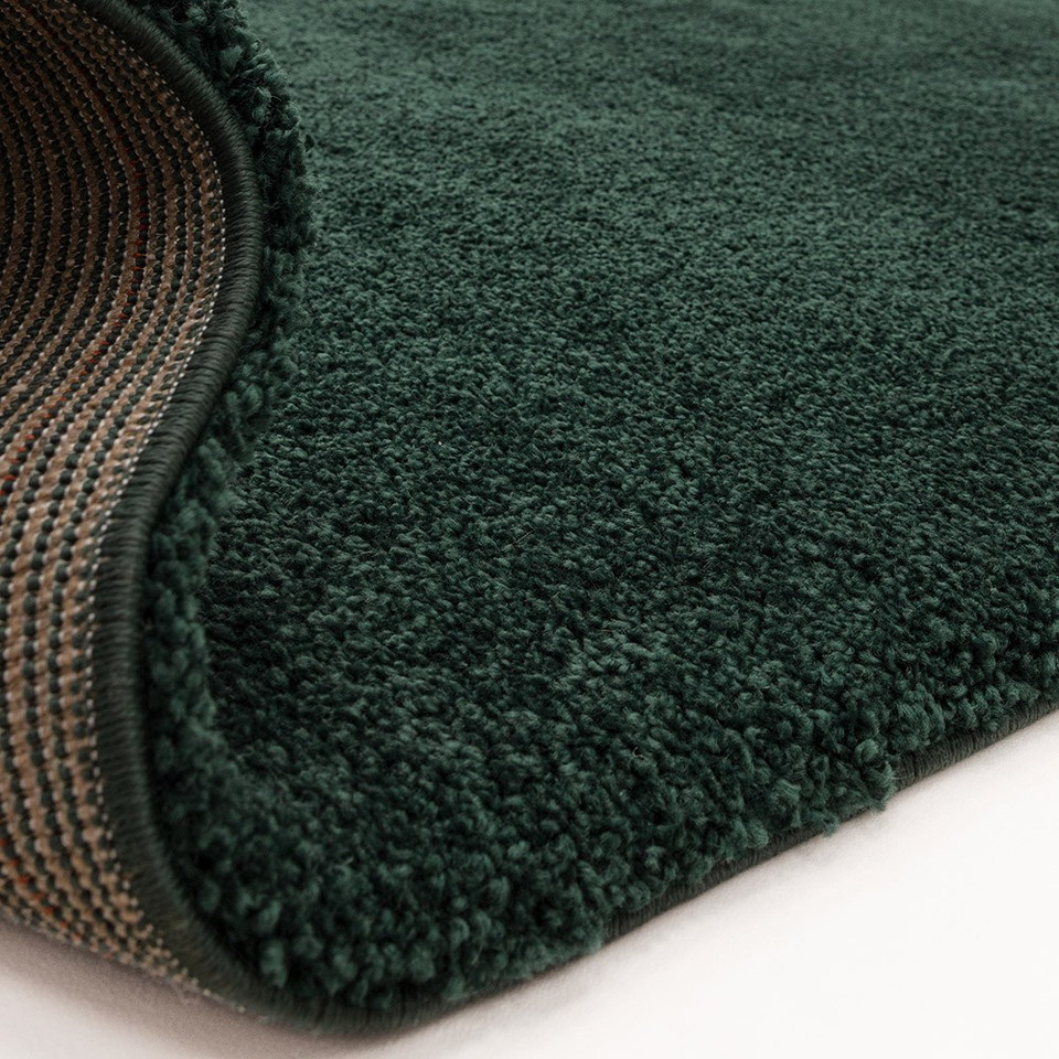 emerald shaggy rug partially folded on white floor