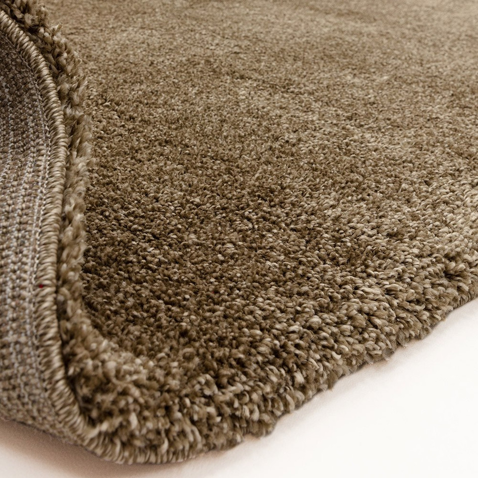 natural shaggy rug partially folded on white floor