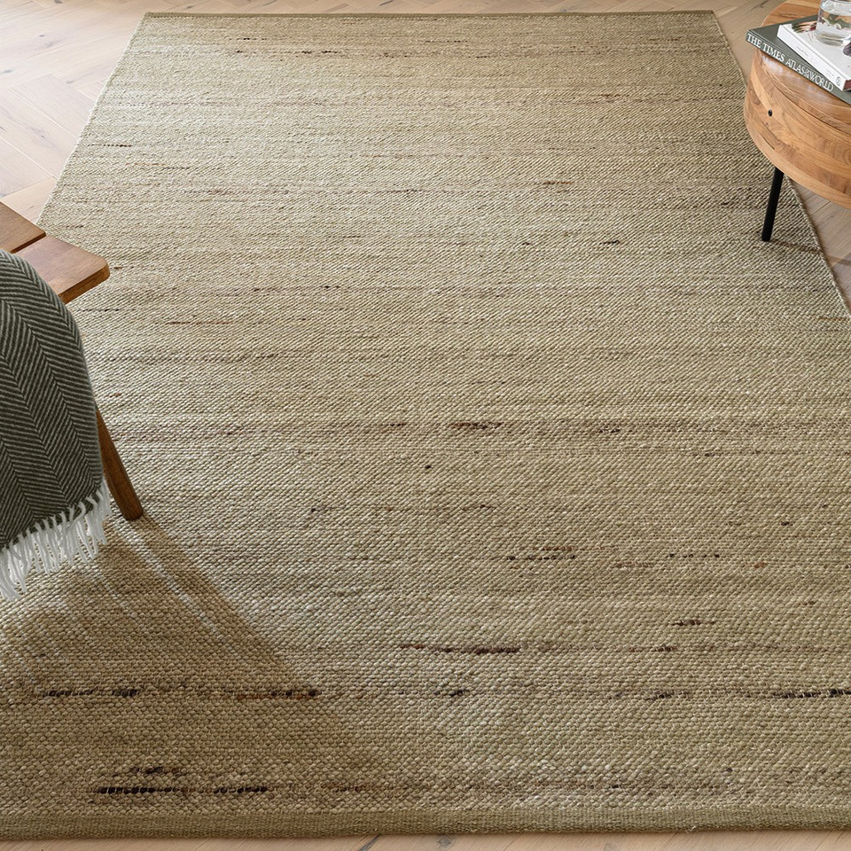 green plain rug in a living room with matching decor