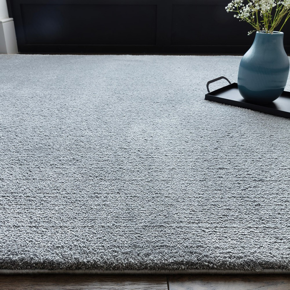 blue plain shaggy rug closeup with a plant pot