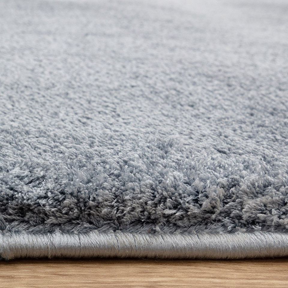 blue plain shaggy rug closeup edge on wood floor