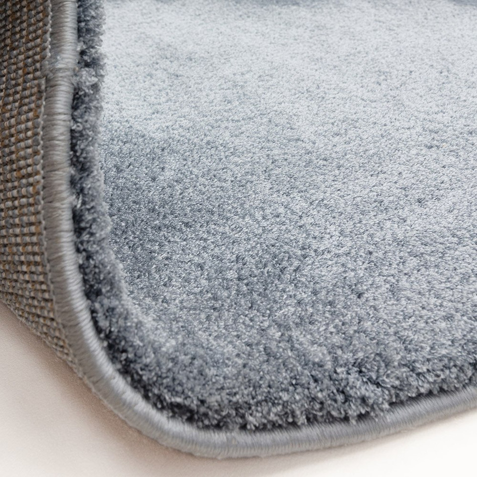 blue plain shaggy rug partial fold on white floor