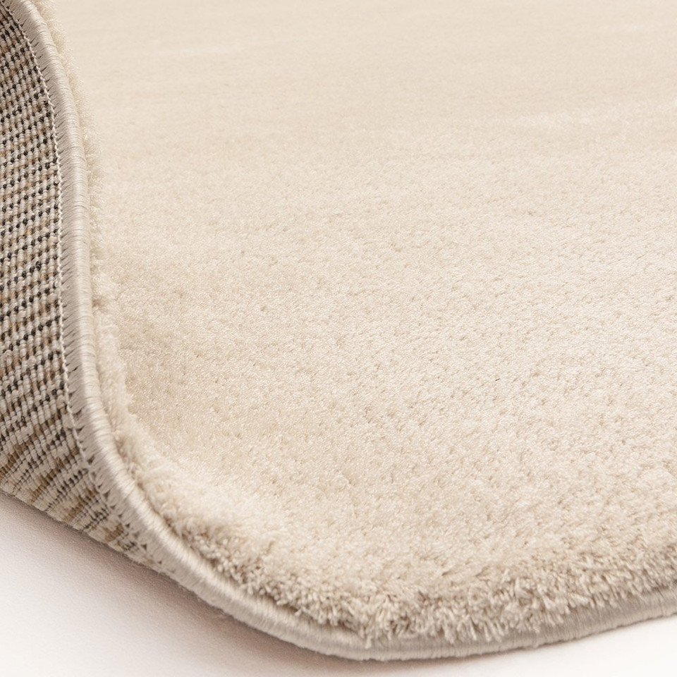 ivory plain shaggy rug partial fold on white floor